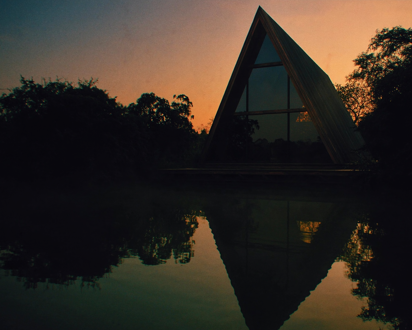 Chalé A-frame ao pôr do sol com reflexo no Lago Corumbá IV