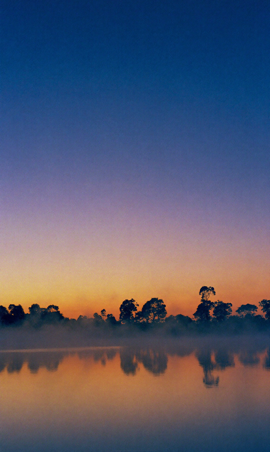 Lago Corumbá IV ao amanhecer com tons azul e laranja