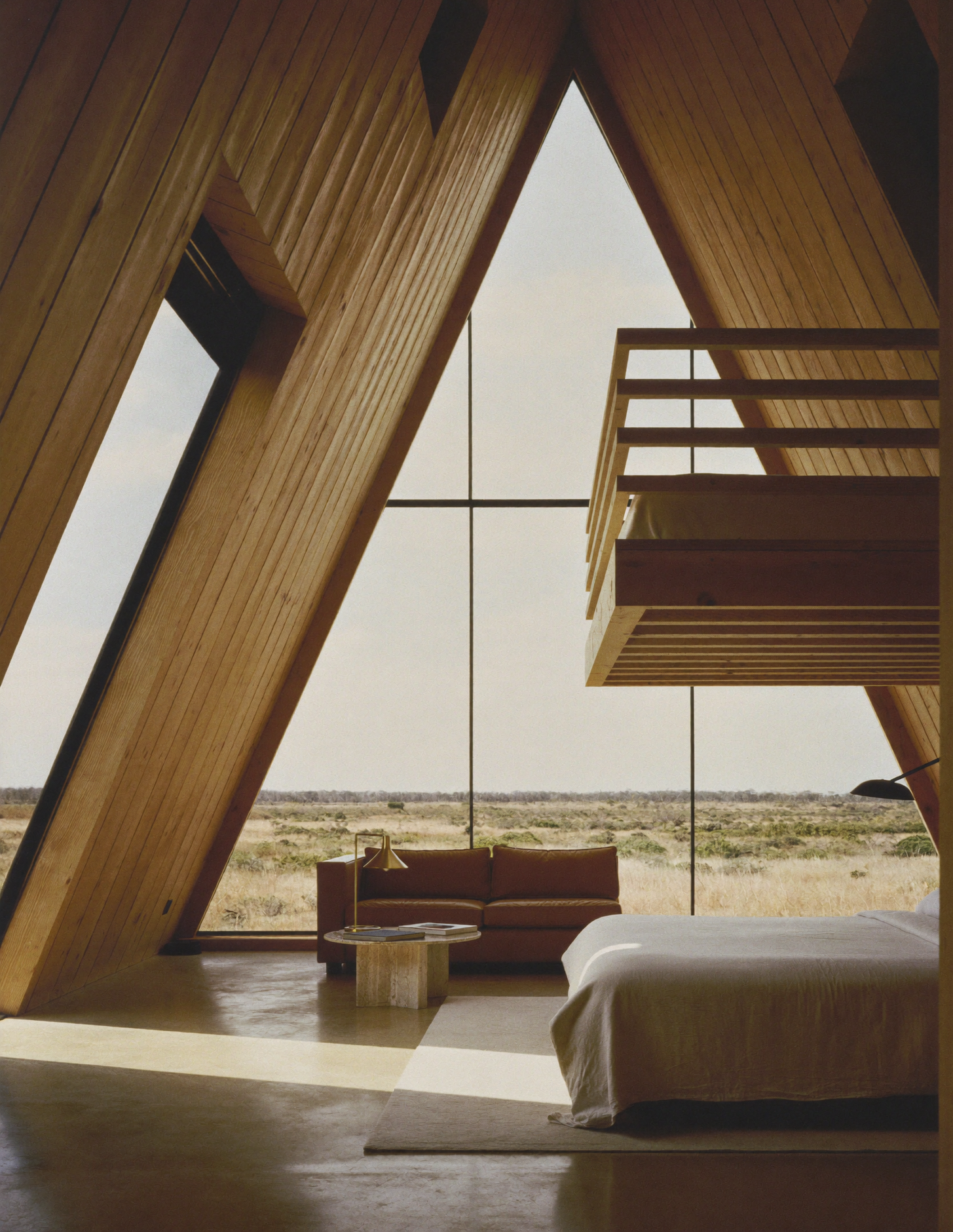 Interior amplo do chalé A-frame com janela para a savana